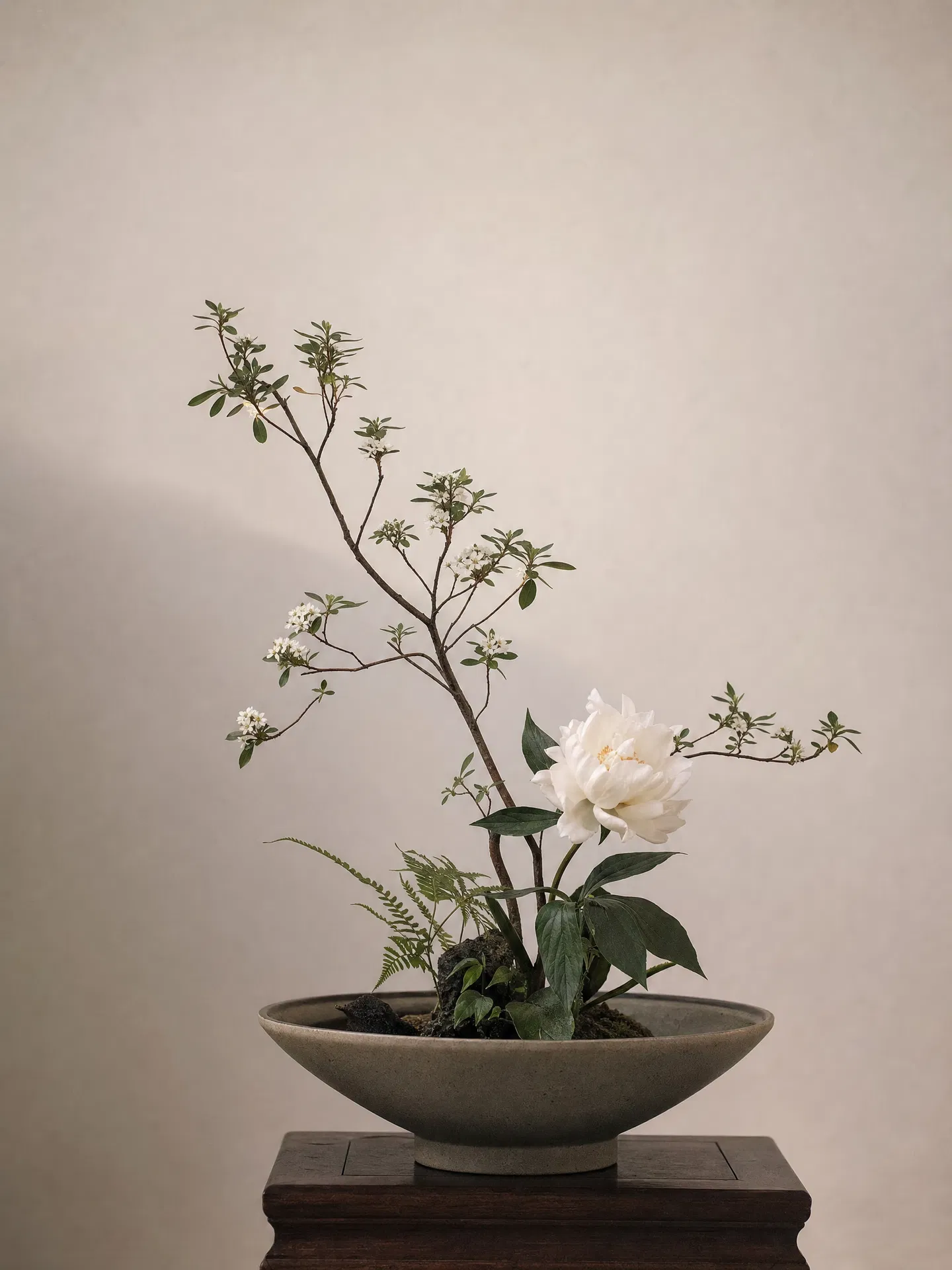 东方传统插花作品：陶器中疏朗有致的枝条与花朵